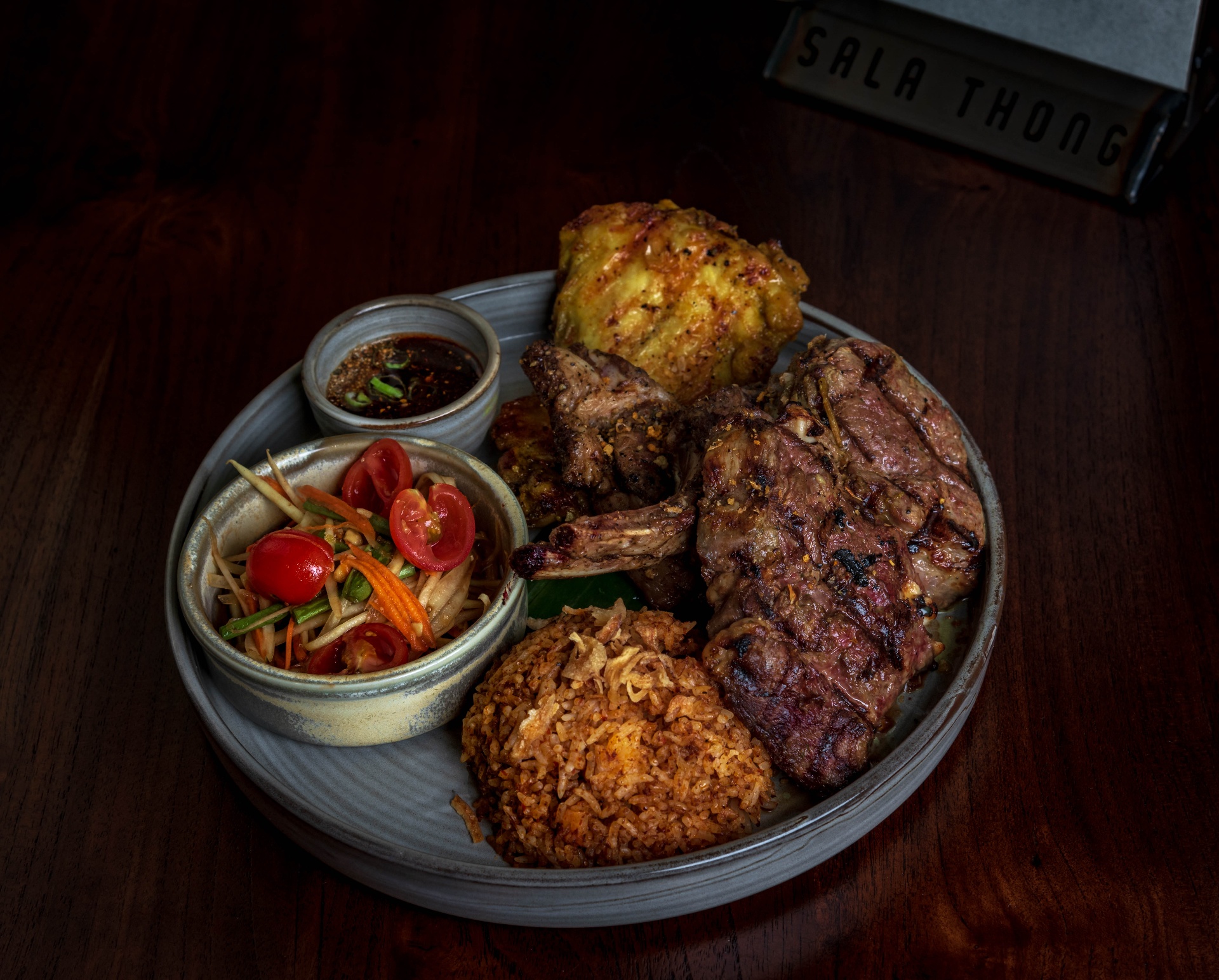 Mixed grill platter with papaya salad and nam jim jaew