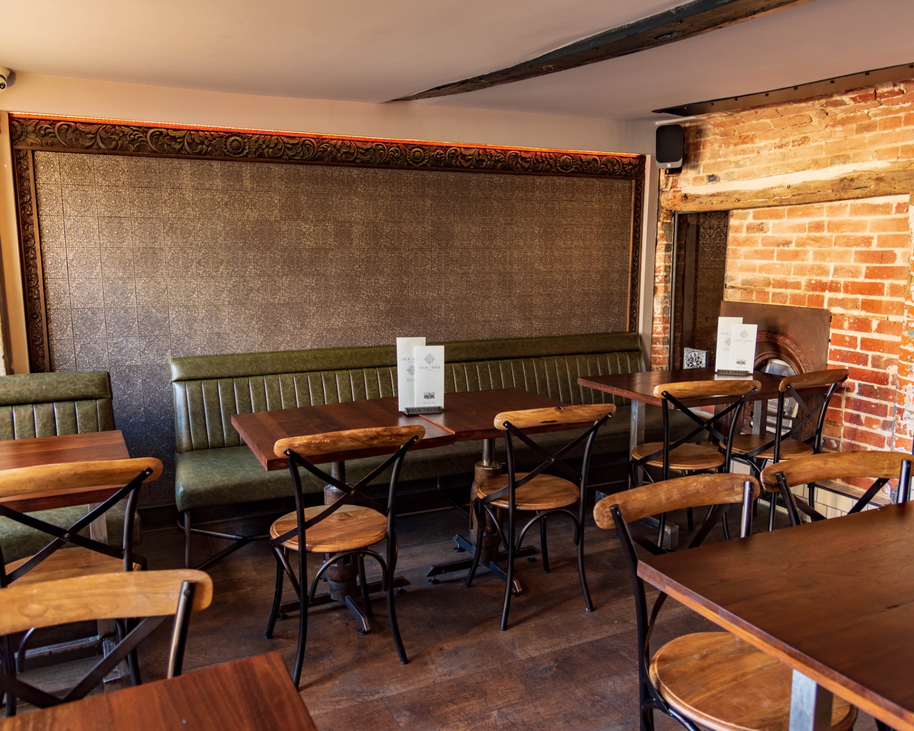Hand-carved teak frame above the banquette